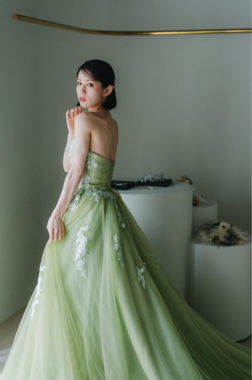 DCE201 モスグリーンフラワーのベアトップドレスを纏う花嫁、頬に手を添えるポーズ