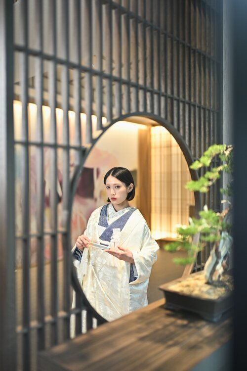円窓の鏡に映る、白扇を手にしたAK18絞りネイビーの振袖姿の花嫁