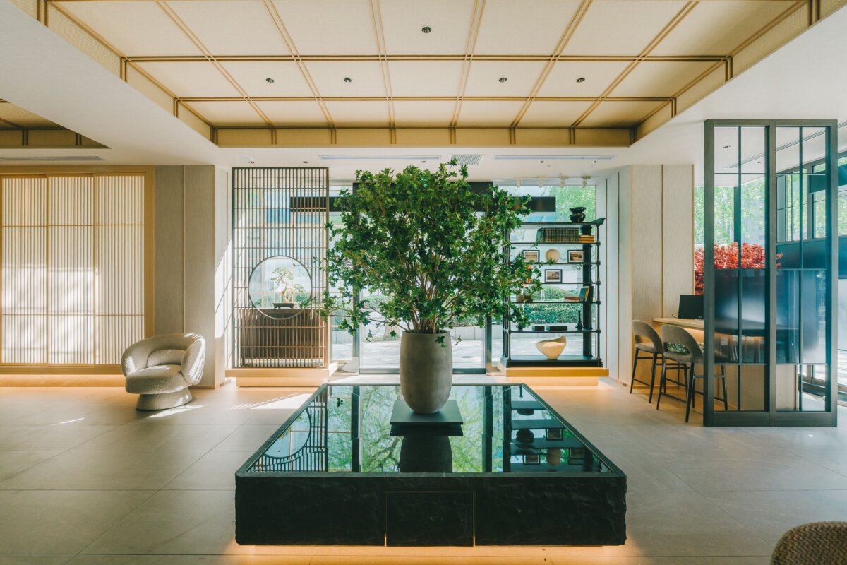 和モダンな店内ロビー、大きな観葉植物と黒い水盤のディスプレイ