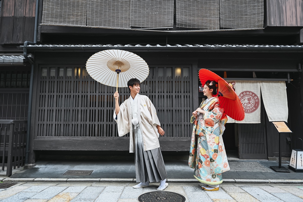 祇園のオシャレな古民家の前で歩いている夫婦