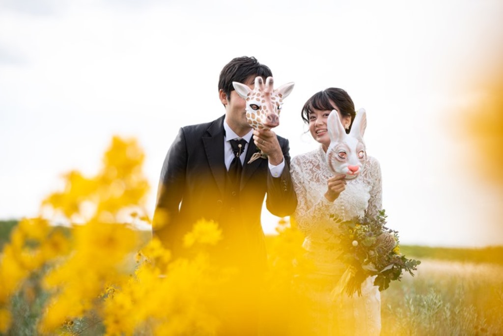 紅葉を背景に並ぶウェディングドレスの新婦とタキシードの新郎。秋の洋装前撮りで撮る紅葉ロケーションフォト