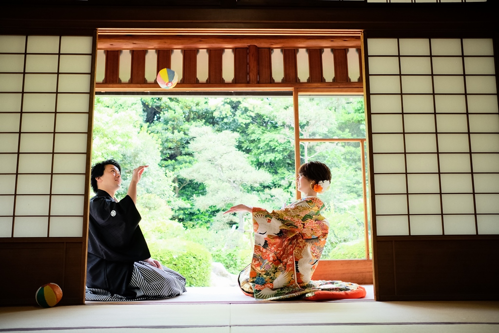 お茶室で紙風船を使って笑顔で遊ぶ和装の新郎新婦。暑い夏でも快適に撮れる室内の和装前撮りフォトウェディング